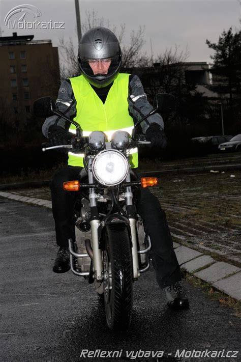 motorkář v reflexní vestě za šera