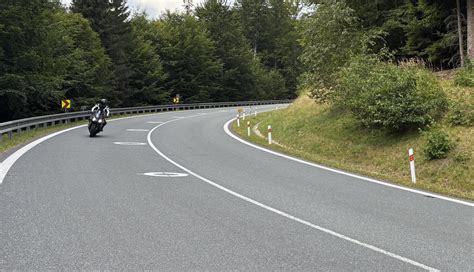 Motorka na šumavské silnici mezi lesy