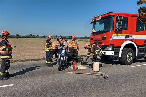 motorkář pracuje pod motocyklem na pojízdném lehátku