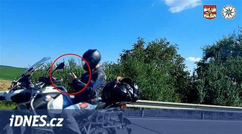 Motorkář ukazuje na překážku u vozovky