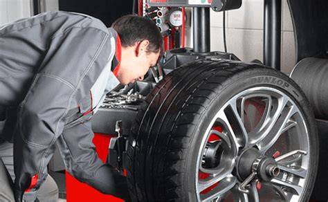 mechanik při vyvažování automobilového kola