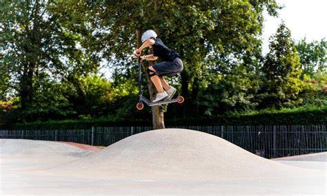 jezdec na freestyle koloběžce ve skateparku